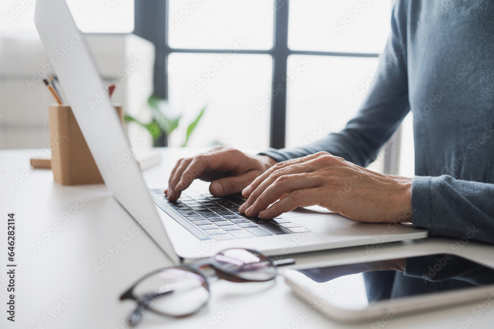 Wall mural man hands typing on computer keyboard closeup, businessman or student using laptop at office, online