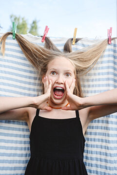 Surprised blond girl with hair in clothespin
