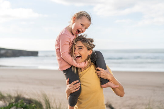 Cheerful mother and daughter enjoying at beach