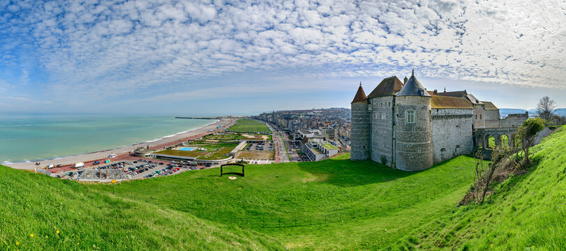 Castle with city near sea under cloudy sky