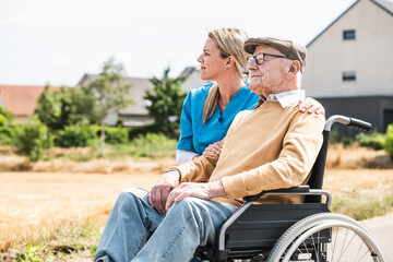 Thoughtful nurse by senior man sitting in wheelchair