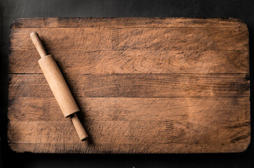Rolling pin on wooden kitchen board