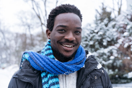 Smiling Young Man Wearing Blue Scarf In Winter