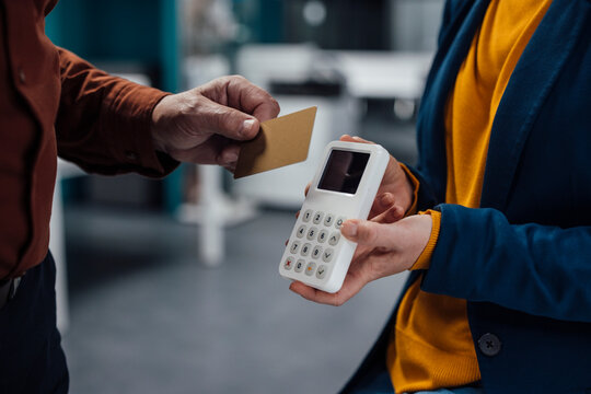 Hand of businessman doing contactless payment at work place