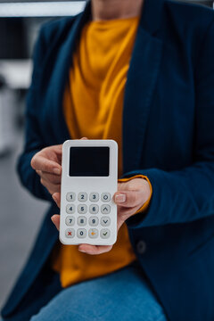 Hands of businesswoman holding modern credit card reader