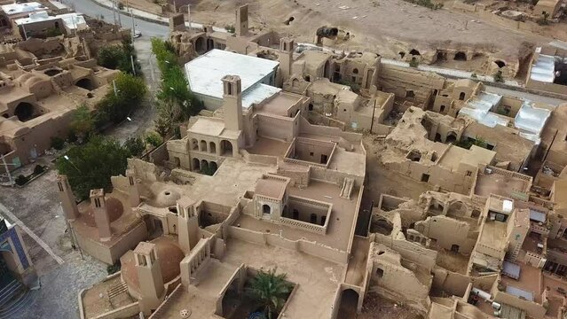 aerial drone shot view of a desert city in aqda ardakan like morocco architecture sand clay adobe mud brick house village in rural area brown color square yard passive design in Persia middle east