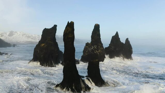 Drone shot flying through the Reynisdrangar rocks, on the coast of wintry Iceland