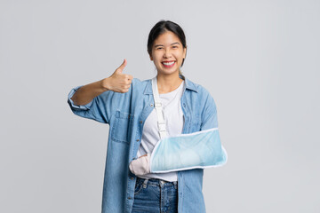 Asian female patient wearing plaster cast and arm support after injury from accident Life and...
