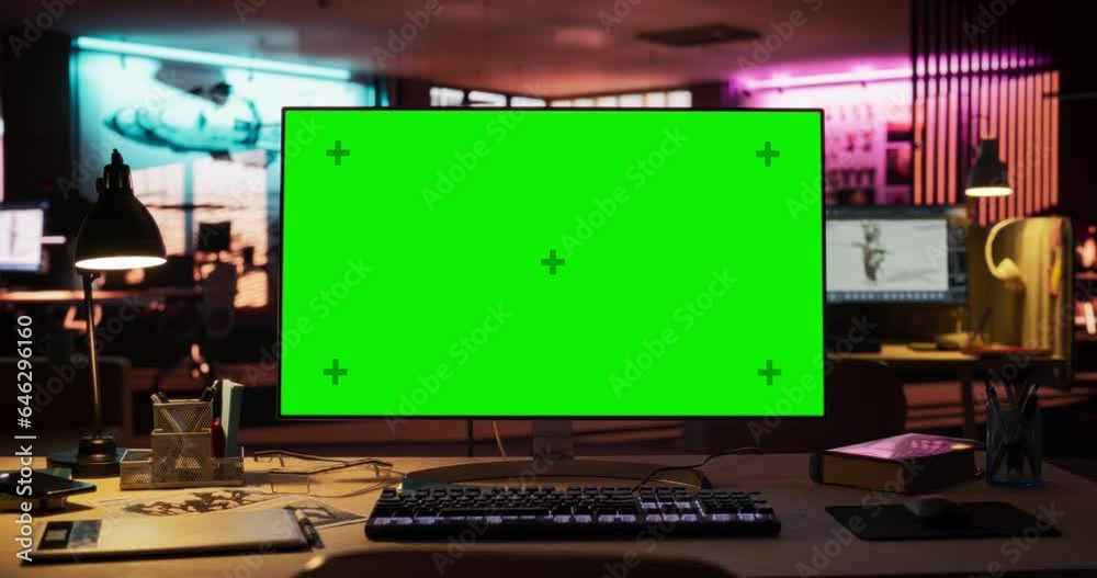 Poster Desktop Computer with Mock Up Green Screen Chroma Key Display Standing on the Desk in the Empty Creative Office Lit by Neon Lights. Monitor in Game Development or Animation Company. Zoom in