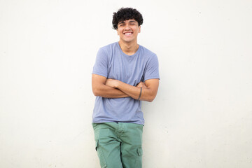 cool guy smiling against white wall with arms crossed