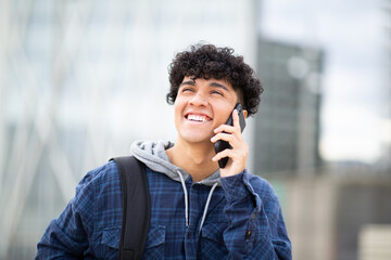 smiling young man talking with mobile phone in city