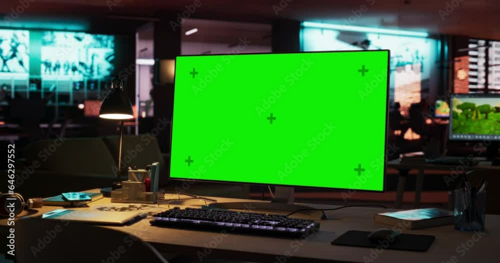 Poster Empty Office of Creative Agency with Art on Walls and Desks with Computers. Office Space with Digital Green Screen Mock Up Chroma Key Monitor Standing at Night on Developer's Table. Zoom Out