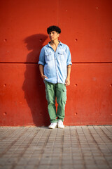 Full body young fashion man by red wall