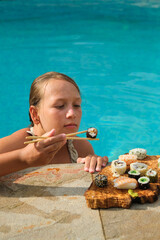 The girl is going to eat sushi by the swiming pool