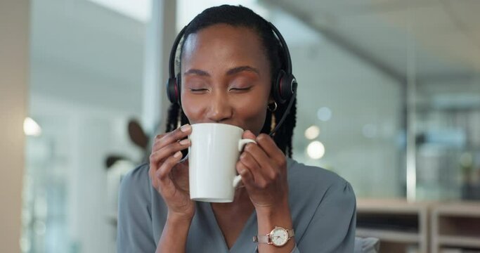 Happy black woman on coffee break at desk in call center, peace and calm in telemarketing office. Smile, relax and drink, tea time for customer support consultant at workplace with cup and headset.