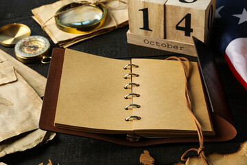 Columbus Day. Wooden calendar with notebook and compass