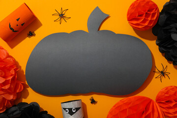 Paper halloween characters and pumpkin on orange background, top view