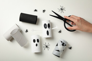 Spiders, scissors in hands and paper sleeves on white background, top view