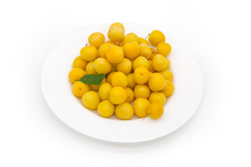 Yellow cherry plums on dish on a white background