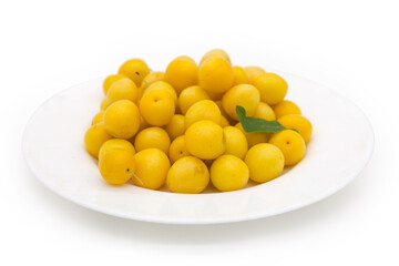 Yellow cherry plums on dish, side view in selective focus