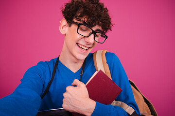Young attractive student posing on a pink background.