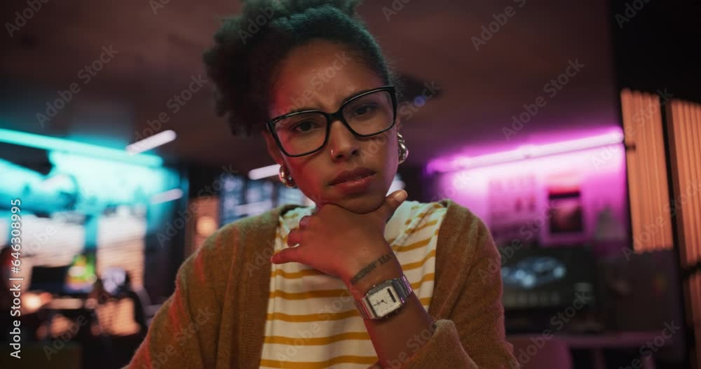 Poster zoom in: stylish young black woman looking at camera with confusion while working on desktop compute