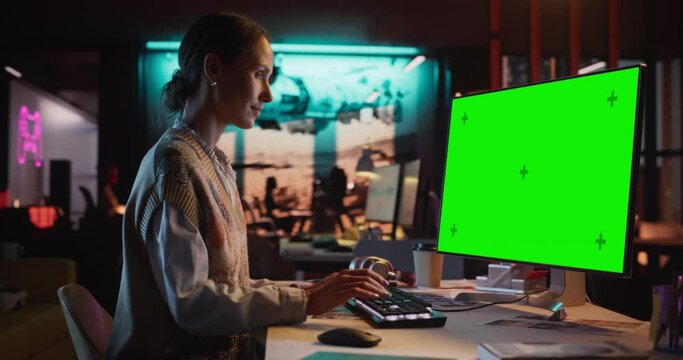 Zoom in Portrait of Young Woman Sitting at Her Desk Using Desktop Computer with Mock-up Green Screen. Female Caucasian Specialist Working on Computer with Chroma Key Display at Creative Agency