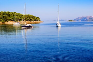 Small yachts and boats in a cozy bay of the Adriatic Sea in the early calm and beautiful morning. Europe, Croatia