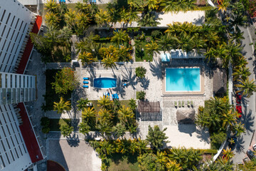 Top view of green hotel territory with pools and tropical palms