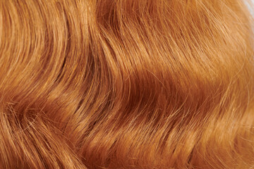 Naklejka premium Close-up view of natural shiny fair hair, bunch of ginger curls background