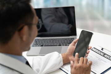 Doctor Smiling working with mobile phones and remote online services at the clinic smart medical doctor high quality service concept