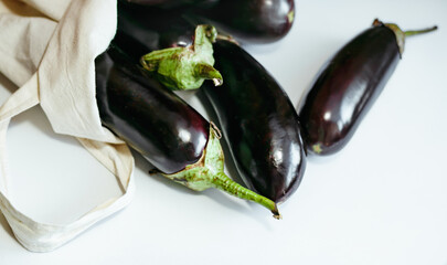 Ripe black eggplants in linen eco shopper. Copy space. Summer village grocery market.