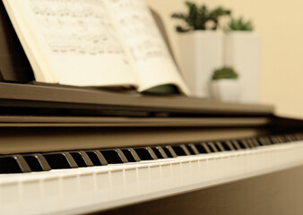 Home piano with selective focus at keys and open sheets