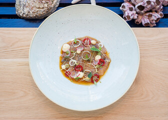 Ceviche on a white plate on a wooden table in restaurant