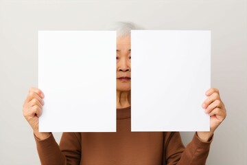 白いボードを体の前に掲げる日本人のおばあさん（メッセージ・白い紙・クリップボード）