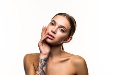 Portrait of beautiful female model touching her glowing, moisturized perfect skin on white background