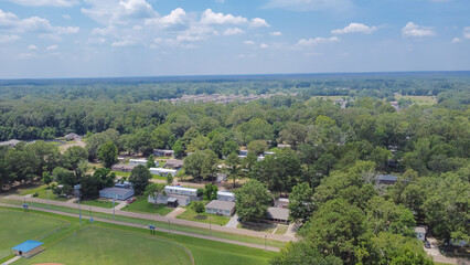 Large baseball fields near row of manufactured, modular, and mobile homes in Richland, Rankin County, Mississippi suburb of Jackson, lush green trees neighborhood