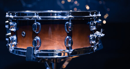 Close-up, snare drum on a blurred background with bokeh lights.