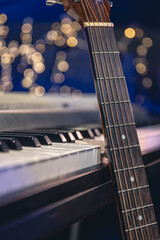 Guitar and piano keys close-up on a blurred background with bokeh.