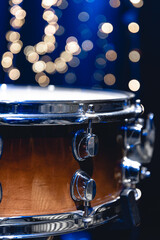 Close-up, snare drum on a blurred background with bokeh lights.