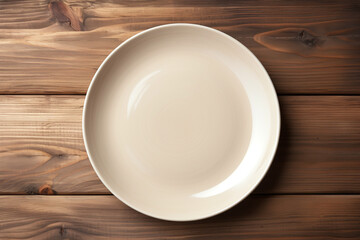 empty beige plate on a dark wooden background, top view, copy space