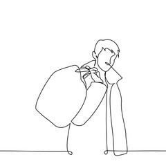 man stands in a coat or jacket with a high collar holding a large bag behind his back and looks at the viewer - one line art vector. concept travel style in cold weather