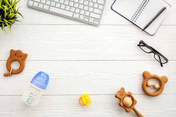 Childcare and working mom concept. Table with computer and kids toys, top view