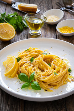 Linguine al limone - pasta with lemon and parmesan on wooden background
