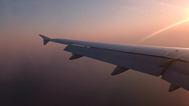 4k video of the sun setting behind an aircraft wing on approach to Luga International Airport in Malta