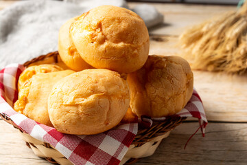 basket with pão de queijo or cheese buns, cheese bread in a wooden table