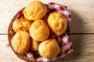 basket with pão de queijo or cheese buns, cheese bread in a wooden table