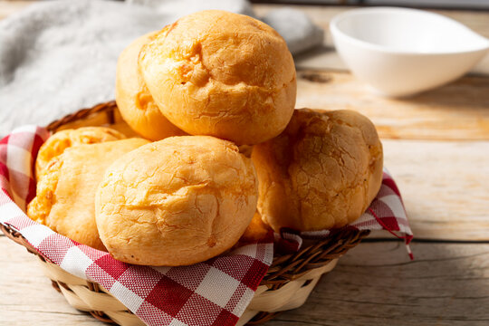 basket with pão de queijo or cheese buns, cheese bread in a wooden table