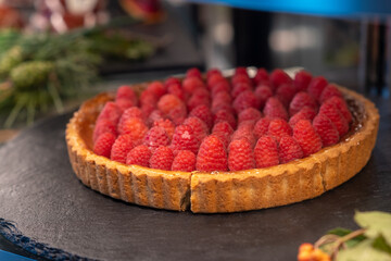 Sweet pastries with berries. Showcase in a candy store. Glass stand with cake eclairs and tartlets....