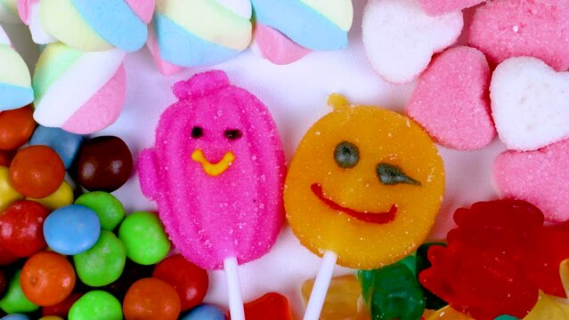 Piles of various kinds of sweets and candies with a focus on the smiling candy
